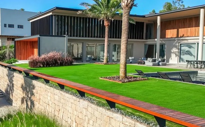 Casa Makoto Paisagismo Uma casa sendo vista de lado, onde mostra o gramado bonito, a piscina e o canto do imóvel